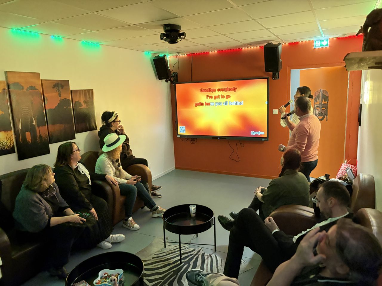 Un groupe partage un moment convivial lors d'une session karaoké chez Team Square