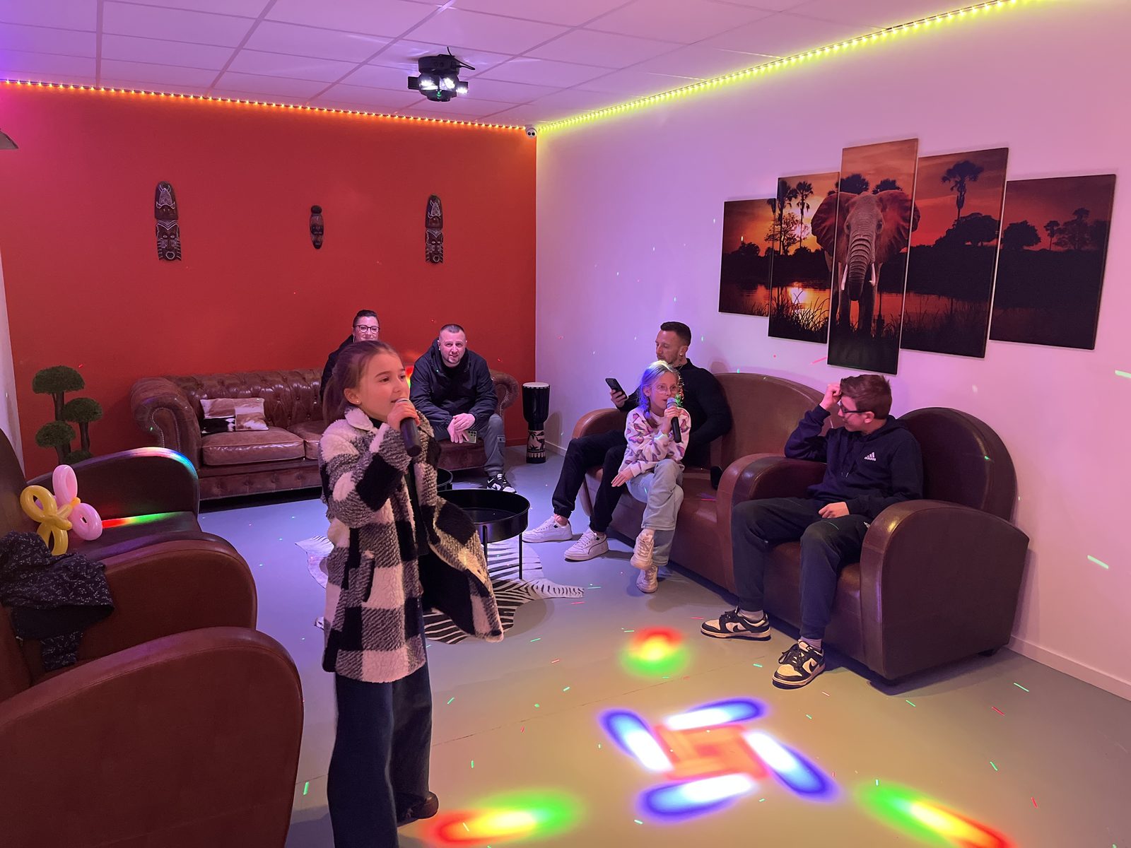 Un groupe d'amis chante ensemble dans la salle Safari chez Team Square